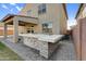 Outdoor kitchen on a paver patio has a tile surround, built in grill, and room for entertaining at 13553 N 141St Ln, Surprise, AZ 85379