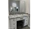 Vanity area featuring granite counters, white cabinets with dark pulls, and gray wood-look tile floors at 14861 S Capistrano Rd, Arizona City, AZ 85123