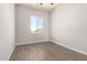 Bright, cozy bedroom featuring a large window and wood-look flooring at 14861 S Capistrano Rd, Arizona City, AZ 85123