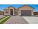 Charming one-story home featuring a two-car garage, desert landscaping, and modern architectural details at 14861 S Capistrano Rd, Arizona City, AZ 85123