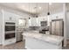 Elegant kitchen with white cabinetry, stainless steel appliances, granite countertops, and a stylish backsplash at 14861 S Capistrano Rd, Arizona City, AZ 85123