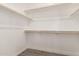 Spacious walk-in closet with multiple wooden shelves and gray flooring at 14861 S Capistrano Rd, Arizona City, AZ 85123