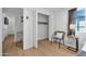Modern bedroom features wood floors, closet, and side table with a lamp and gray accent chair at 1510 W 7Th Dr, Mesa, AZ 85202