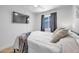 Modern bedroom with mounted TV, light gray walls, and natural light streaming through the window at 1510 W 7Th Dr, Mesa, AZ 85202