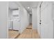 Bright hallway with access to a laundry room, featuring neutral flooring and white doors at 1510 W 7Th Dr, Mesa, AZ 85202