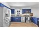 Well-lit kitchen with stainless steel appliances, granite countertops, and blue cabinets at 1510 W 7Th Dr, Mesa, AZ 85202