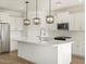 Bright, modern kitchen features white cabinets, quartz counters, stainless appliances, and stylish pendant lighting at 16071 W Remuda Dr, Surprise, AZ 85387