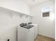 Laundry room with white washer and dryer and built-in shelving at 16071 W Remuda Dr, Surprise, AZ 85387