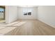 Bright living room with wood-look tile flooring and a large window at 16071 W Remuda Dr, Surprise, AZ 85387