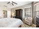 Cozy bedroom with a ceiling fan, wardrobe, and a comfortable chair near the bright window at 16384 W Salado Creek Dr, Surprise, AZ 85387
