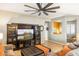 Open living room with comfortable seating, ceiling fan, tile floors, and an entertainment center at 16384 W Salado Creek Dr, Surprise, AZ 85387