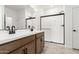 Bright bathroom with a double sink vanity, modern fixtures, and a glass door shower at 17043 W Fetlock Trl, Surprise, AZ 85387