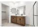 Bathroom with double vanity, modern fixtures, and a glass door shower, and a view into the walk-in closet at 17043 W Fetlock Trl, Surprise, AZ 85387