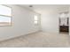 Bright bedroom with neutral carpet, multiple windows, and an ensuite bathroom at 17043 W Fetlock Trl, Surprise, AZ 85387