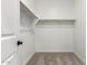Walk-in closet featuring carpet flooring, white walls, and shelving with room for customization at 17043 W Fetlock Trl, Surprise, AZ 85387