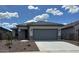 Charming single-story home featuring a gray roof, neutral stucco and a spacious two-car garage at 17043 W Fetlock Trl, Surprise, AZ 85387