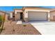 Charming single-story home with a gray garage door and low-maintenance gravel landscaping at 17043 W Fetlock Trl, Surprise, AZ 85387