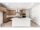 Well-lit kitchen with stainless steel appliances, a kitchen island, and wood cabinets at 17043 W Fetlock Trl, Surprise, AZ 85387
