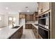 A well-lit kitchen featuring stainless steel appliances, a kitchen island, and wood cabinets at 17043 W Fetlock Trl, Surprise, AZ 85387