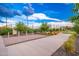 Recreation area features seating, lush grass, patio areas, string lights, and orange flowers with community clubhouse in the background at 17244 W West Wind Dr, Surprise, AZ 85387