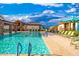Inviting community pool featuring clear turquoise water, lounge chairs, and shaded seating areas under a sunny sky at 17244 W West Wind Dr, Surprise, AZ 85387