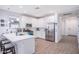 Well-lit kitchen featuring stainless steel appliances, white cabinetry, and a breakfast bar with modern stools at 17244 W West Wind Dr, Surprise, AZ 85387