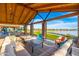 Relaxing outdoor patio with comfortable seating, stone pillars, wood ceiling and a view of the lake at 17244 W West Wind Dr, Surprise, AZ 85387