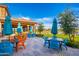 Charming outdoor tables with colorful seating under umbrellas and lush landscaping at 17244 W West Wind Dr, Surprise, AZ 85387