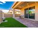 Outdoor patio with artificial grass, stone pavers, and a covered seating area, perfect for relaxation and entertainment at 17244 W West Wind Dr, Surprise, AZ 85387