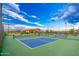 Well-maintained pickleball courts with a blue and green color scheme, surrounded by manicured landscaping and blue skies at 17244 W West Wind Dr, Surprise, AZ 85387