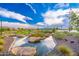 A tranquil pond with rock islands, lush vegetation, and clear reflections of the blue sky at 17244 W West Wind Dr, Surprise, AZ 85387