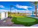 Scenic putting green featuring manicured lawns, palm trees, and distant views of a tranquil lake at 17244 W West Wind Dr, Surprise, AZ 85387