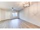 Spacious living room with wood-look flooring, a ceiling fan, and a modern chandelier at 1961 N Hartford St # 1149, Chandler, AZ 85225