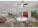 Bright living space with modern ceiling fan, dining set, comfortable seating, and natural light at 19982 N Tealstone Dr, Surprise, AZ 85374