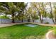 Backyard with a trampoline and landscaped borders surrounded by trees at 2024 E Taurus Pl, Chandler, AZ 85249