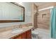 A bathroom featuring a granite countertop, decorative mirror, and tiled shower-tub combo at 2024 E Taurus Pl, Chandler, AZ 85249