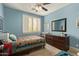 Bedroom with a ceiling fan, carpeted floors, and large window with shutters at 2024 E Taurus Pl, Chandler, AZ 85249