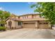 Beige two-story home featuring a wide driveway and three-car garage at 2024 E Taurus Pl, Chandler, AZ 85249