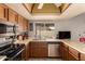 Efficient kitchen featuring stainless steel appliances, wooden cabinetry, and a window offering natural light at 2324 E Cortez St, Phoenix, AZ 85028