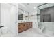 Bathroom with a double vanity, wood cabinets, modern fixtures, and a glass-enclosed shower at 2546 E Roma Ave, Phoenix, AZ 85016