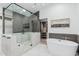 Modern bathroom with a freestanding tub, a glass-enclosed shower, and a walk-in closet at 2546 E Roma Ave, Phoenix, AZ 85016