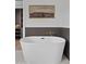 Elegant white soaking tub with a decorative painting on the wall and modern faucet at 2546 E Roma Ave, Phoenix, AZ 85016