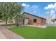 Landscaped home exterior featuring artificial turf, desert plants, brick accents, and a walkway to the front door at 2546 E Roma Ave, Phoenix, AZ 85016