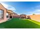 Wide angle shot of a backyard featuring synthetic grass, a patio set, and privacy walls at 25627 N 163Rd Dr, Surprise, AZ 85387