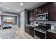 Modern kitchen with dark wood cabinets, granite countertops, and stainless steel appliances at 25627 N 163Rd Dr, Surprise, AZ 85387