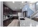 A modern kitchen featuring granite countertops, stainless steel appliances, and dark wood cabinets at 25627 N 163Rd Dr, Surprise, AZ 85387