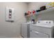 This laundry room is equipped with a washer, dryer, and shelving, offering great convenience for laundry tasks at 25627 N 163Rd Dr, Surprise, AZ 85387