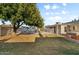 Lush backyard featuring mature tree, pool with secure fencing, and a covered patio at 2616 E Des Moines St, Mesa, AZ 85213