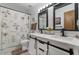 Updated bathroom with double sinks, a floral shower curtain, and modern fixtures at 2616 E Des Moines St, Mesa, AZ 85213