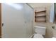 Cozy bathroom featuring frosted glass shower, toilet, and built-in wooden storage shelves at 2616 E Des Moines St, Mesa, AZ 85213